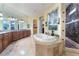 An elegant bathroom features a large bathtub, walk-in shower, and double vanity at 761 Romano Ln, Henderson, NV 89012