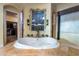Bright bathroom featuring a jacuzzi tub nestled in front of a large window at 761 Romano Ln, Henderson, NV 89012