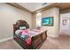 Bedroom featuring elegant wooden bed frame, neutral walls, and view into ensuite bathroom at 761 Romano Ln, Henderson, NV 89012