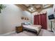 Bedroom with tray ceiling and warm lighting featuring a small dresser and wall-mounted TV at 761 Romano Ln, Henderson, NV 89012