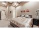 Bedroom with tray ceiling and warm lighting featuring a small dresser and flower art at 761 Romano Ln, Henderson, NV 89012
