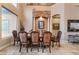 Elegant dining room featuring detailed chairs, table setting, and stone archway detail above an art piece at 761 Romano Ln, Henderson, NV 89012