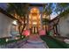 Elegant home with manicured lawn and fountain, stone pathway, and arched entryway framed by mature trees at 761 Romano Ln, Henderson, NV 89012