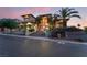 Beautiful home with an arched entryway, steps to the front door, professionally landscaped front yard and palm trees at dusk at 761 Romano Ln, Henderson, NV 89012