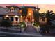Elegant stucco home with an arched entryway, steps to the front door, and professionally landscaped front yard at sunset at 761 Romano Ln, Henderson, NV 89012