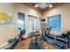 A home gym features hardwood floors and large windows for a bright and airy workout space at 761 Romano Ln, Henderson, NV 89012