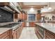 This kitchen features granite countertops, stainless appliances, and custom wood cabinets for storage at 761 Romano Ln, Henderson, NV 89012