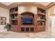 Custom built-in entertainment center in living room with decorative shelving and cabinets at 761 Romano Ln, Henderson, NV 89012