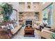 Living room with stone fireplace, built-in shelving, large windows, and neutral-toned walls at 761 Romano Ln, Henderson, NV 89012