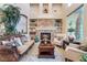 Living room with stone fireplace, built-in shelving, large windows, and neutral-toned walls at 761 Romano Ln, Henderson, NV 89012