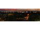 Beautiful night view of the Las Vegas strip from a luxury property with mature landscaping in the foreground at 761 Romano Ln, Henderson, NV 89012