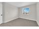 Neutral bedroom features carpet, white trim, and a large window with neighborhood views at 8379 Drop Camp St, Las Vegas, NV 89123