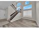 Bright entryway featuring wood-look floors, staircase with dark wood banister and a large window at 8379 Drop Camp St, Las Vegas, NV 89123