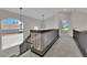 Upstairs hallway with neutral carpet, dark wood banister and modern lighting fixtures at 8379 Drop Camp St, Las Vegas, NV 89123
