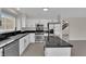 Bright white kitchen with stainless steel appliances, granite countertops, and an island cooktop at 8379 Drop Camp St, Las Vegas, NV 89123
