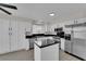 Bright white kitchen with stainless steel appliances, granite countertops, and an island cooktop at 8379 Drop Camp St, Las Vegas, NV 89123