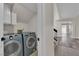 Efficient laundry room features side-by-side washer and dryer, and convenient overhead cabinet storage at 8379 Drop Camp St, Las Vegas, NV 89123