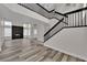 Bright, open living room with modern fireplace, wood flooring, and staircase leading to upper level at 8379 Drop Camp St, Las Vegas, NV 89123