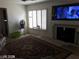 Comfortable living room featuring plantation shutters, fireplace and a bright television at 8769 Country View Ave, Las Vegas, NV 89129