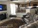 Open-concept living room with fireplace, sofa, and view of the bright, functional kitchen at 8769 Country View Ave, Las Vegas, NV 89129
