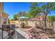 Charming backyard with gravel, patio, mature trees, and outdoor dining set perfect for relaxing at 8800 Crescent Ridge Ln, Las Vegas, NV 89134
