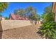 Spacious backyard featuring gravel, block wall, mature trees, and lush plants for enhanced privacy at 8800 Crescent Ridge Ln, Las Vegas, NV 89134