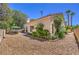 Charming backyard featuring gravel, mature trees, lush landscaping, and a cozy patio with seating at 8800 Crescent Ridge Ln, Las Vegas, NV 89134