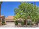 Charming single-story home featuring a well-manicured front yard and a two-car garage at 8800 Crescent Ridge Ln, Las Vegas, NV 89134