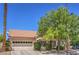 A lovely single-Gathering home featuring a well-manicured front yard with large shade trees at 8800 Crescent Ridge Ln, Las Vegas, NV 89134