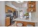 Updated kitchen showcasing stainless steel appliances, wood cabinets, and breakfast bar seating at 8800 Crescent Ridge Ln, Las Vegas, NV 89134