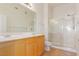 Bathroom featuring a double sink vanity, a large mirror, and a glass-enclosed shower at 8805 Jeffreys St # 1003, Las Vegas, NV 89123