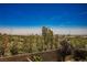 Scenic backyard view featuring lush greenery, a brick fence, and city views under a clear, blue sky at 920 Cirrus Cloud Ave, Las Vegas, NV 89138