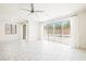 Spacious living room with white tile flooring, natural light from sliding glass doors, and a ceiling fan at 920 Cirrus Cloud Ave, Las Vegas, NV 89138