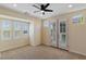 Bright bedroom features a ceiling fan, neutral carpet, and french doors leading to a private balcony at 9240 Northfield Park Ct, Las Vegas, NV 89148