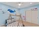 Themed bedroom with ocean-inspired murals, ceiling fan and carpeted floors at 9240 Northfield Park Ct, Las Vegas, NV 89148