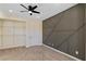 Bedroom with a ceiling fan, neutral carpet, a built-in closet shelf and a dark accent wall at 9240 Northfield Park Ct, Las Vegas, NV 89148