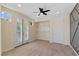Bedroom with a ceiling fan, neutral carpet, a built-in closet shelf and french doors to balcony at 9240 Northfield Park Ct, Las Vegas, NV 89148