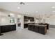 Open concept kitchen with dark cabinets, tile floors, and large island with granite countertops at 9240 Northfield Park Ct, Las Vegas, NV 89148