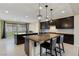 Modern kitchen featuring pendant lighting, dark cabinetry, a spacious granite countertop, and bar stool seating at 9240 Northfield Park Ct, Las Vegas, NV 89148