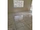 Living room with marble-look floor tiles, a large window, and sliding door access to the backyard at 9617 Pine River Ln, Las Vegas, NV 89123