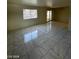 Spacious living room featuring marble-look floor tiles throughout, and sliding door access to the exterior at 9617 Pine River Ln, Las Vegas, NV 89123