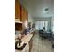 Cozy kitchen featuring ample cabinet space, tiled floors, and a dining area bathed in natural light from the nearby window at 9801 Bradford Summit St, Las Vegas, NV 89183