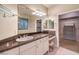 Bathroom featuring a vanity with marble countertop, a large mirror, and walk-in closet at 10300 Wellside Hill Ave, Las Vegas, NV 89145