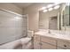 Bright bathroom featuring a shower-tub combination and a large vanity mirror at 10300 Wellside Hill Ave, Las Vegas, NV 89145