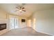 Bright bedroom with a ceiling fan, fireplace, outdoor access, and a door to the bathroom at 10300 Wellside Hill Ave, Las Vegas, NV 89145