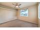 Bedroom featuring a ceiling fan and a large window looking out to the neighborhood at 10300 Wellside Hill Ave, Las Vegas, NV 89145