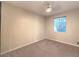 Neutral bedroom with neutral carpet, a ceiling fan, and a bright window at 10300 Wellside Hill Ave, Las Vegas, NV 89145