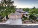 Home exterior featuring a three-car garage, manicured landscaping, and a tile roof at 10300 Wellside Hill Ave, Las Vegas, NV 89145
