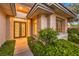 Close up of the front entrance with a custom door, transom window, and manicured shrubs at 10300 Wellside Hill Ave, Las Vegas, NV 89145