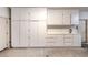Organized garage space featuring storage cabinets and a work bench at 10300 Wellside Hill Ave, Las Vegas, NV 89145
